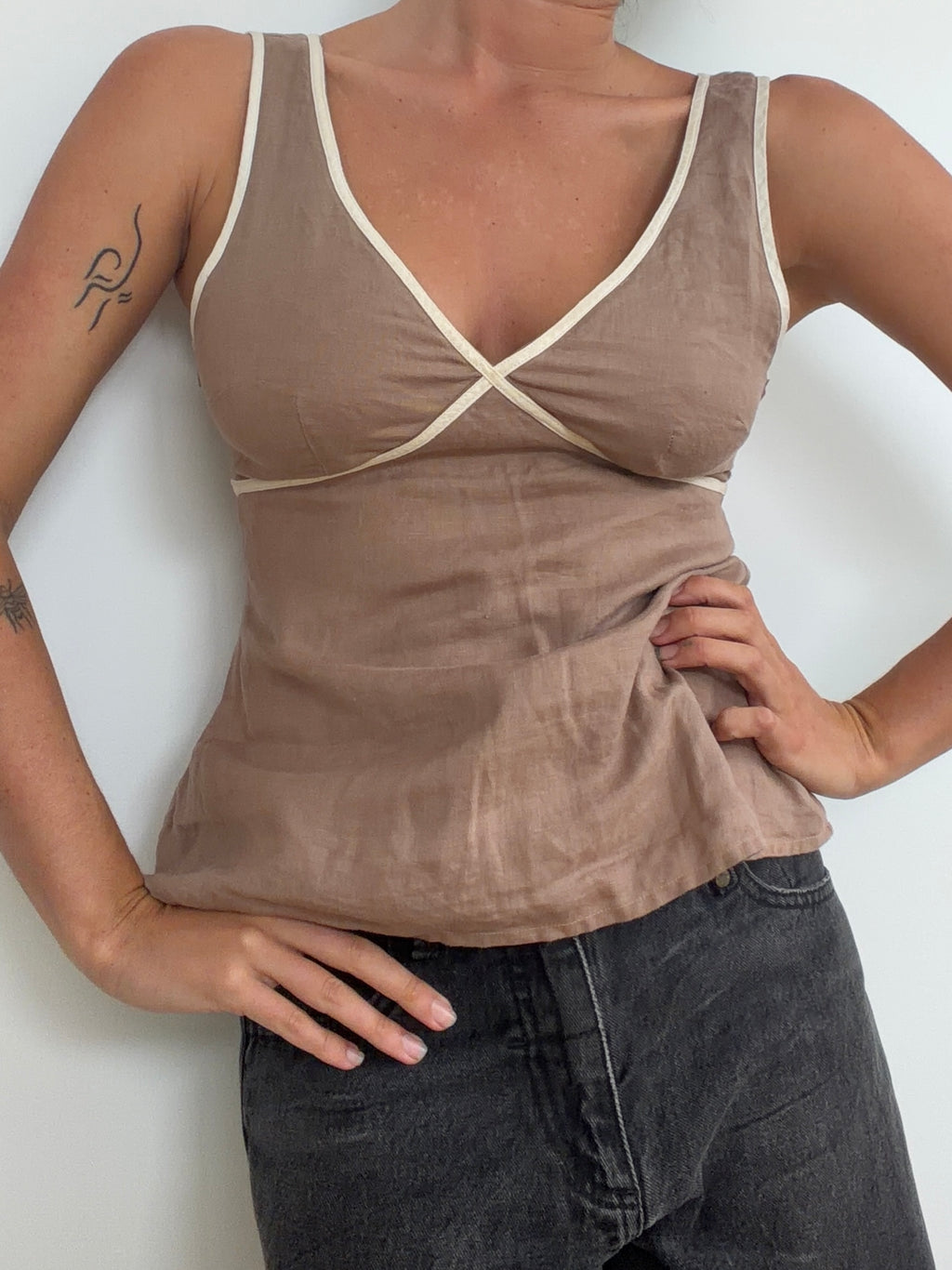 Taupe top worn with jeans showing curved contrast-trim bust seams