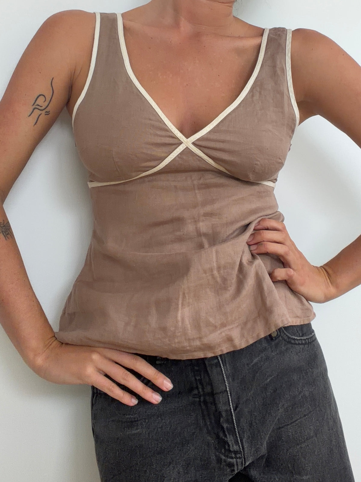 Taupe top worn with jeans showing curved contrast-trim bust seams