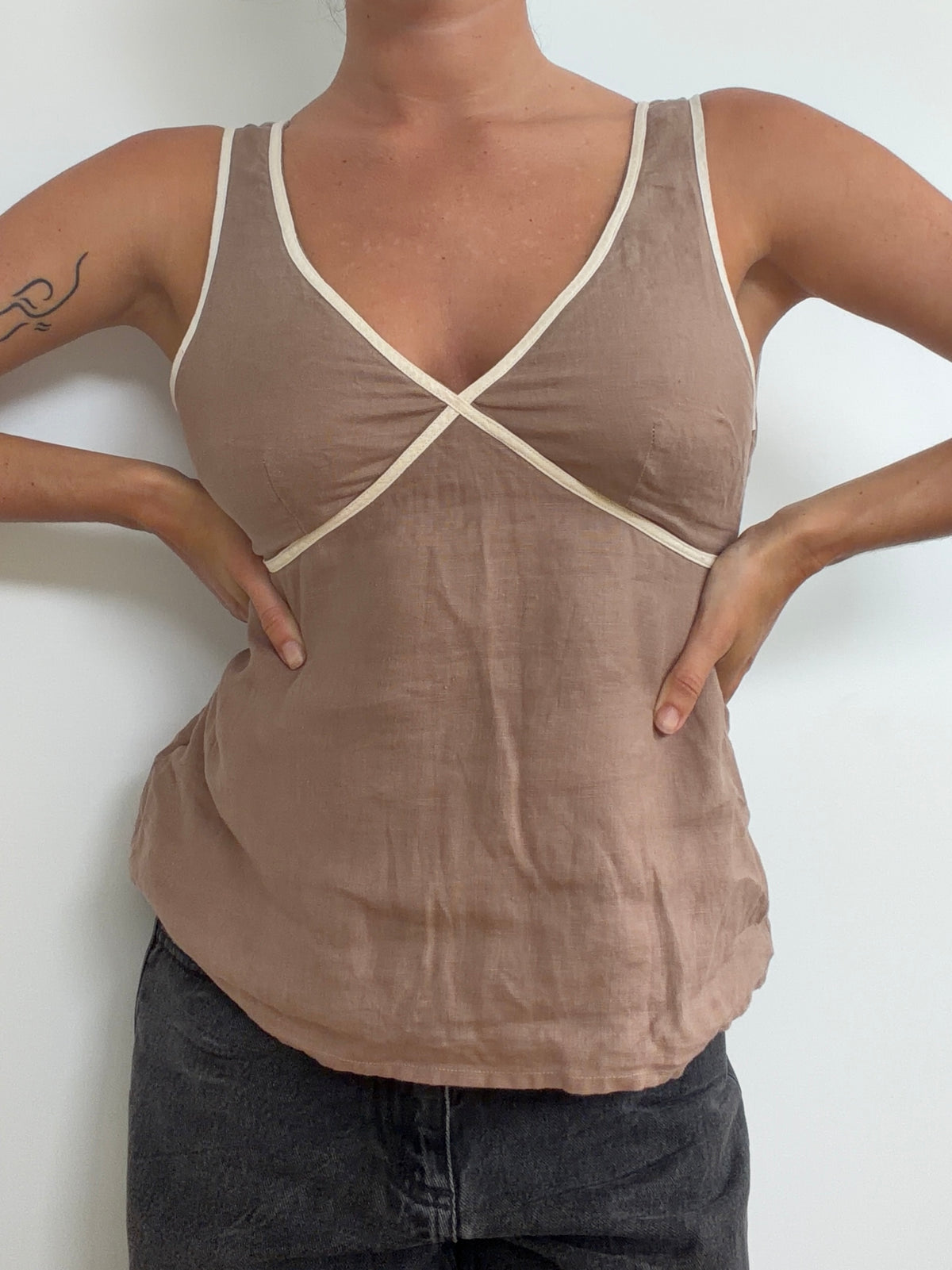 Front view of taupe sleeveless top with cream contrast trim