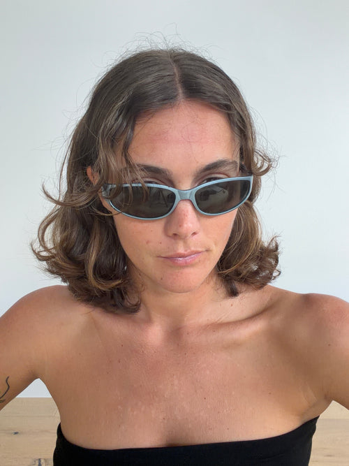 Front view of blue-toned Y2K sunglasses with dark lenses, worn