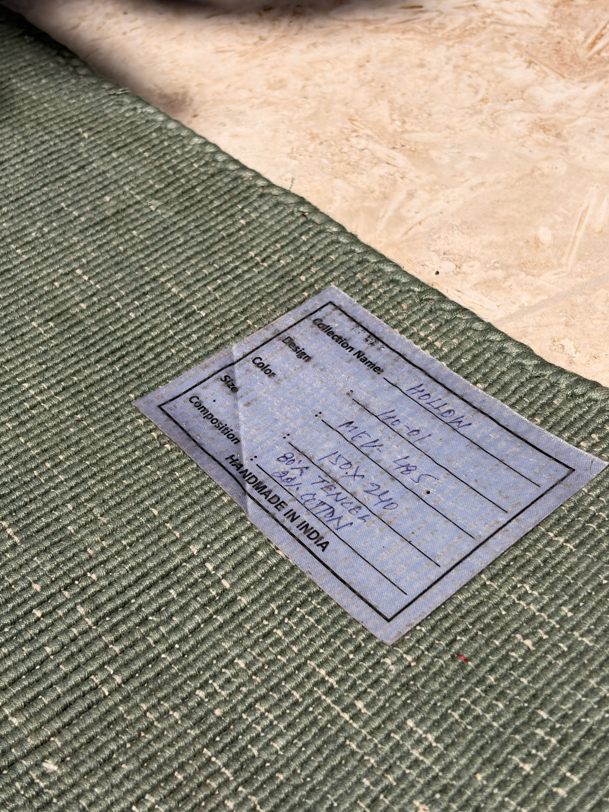 Full view of sage-grey Woven Treasures rug photographed outdoors with leaf shadows