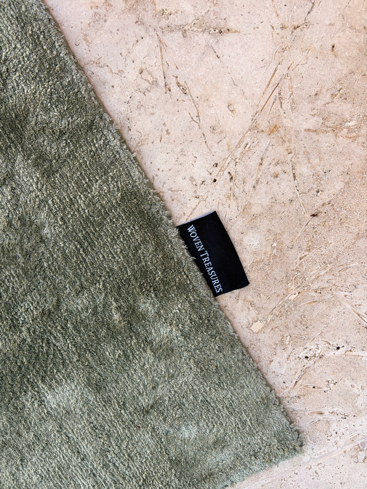 Corner detail showing rug texture and Woven Treasures brand tag
