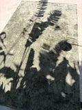 Full-length view of sage-grey rug with plant shadows